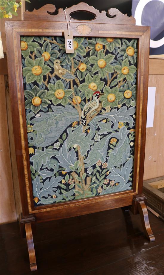 An Edwardian inlaid mahogany firescreen inset woolwork panel in a William Morris-style bird and fruit design